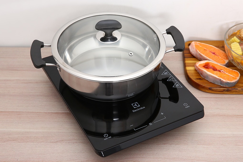 Bếp từ đơn Electrolux màu đen đặt nồi inox có nắp kính trên mặt bếp cảm ứng tùy chỉnh nhiệt độ