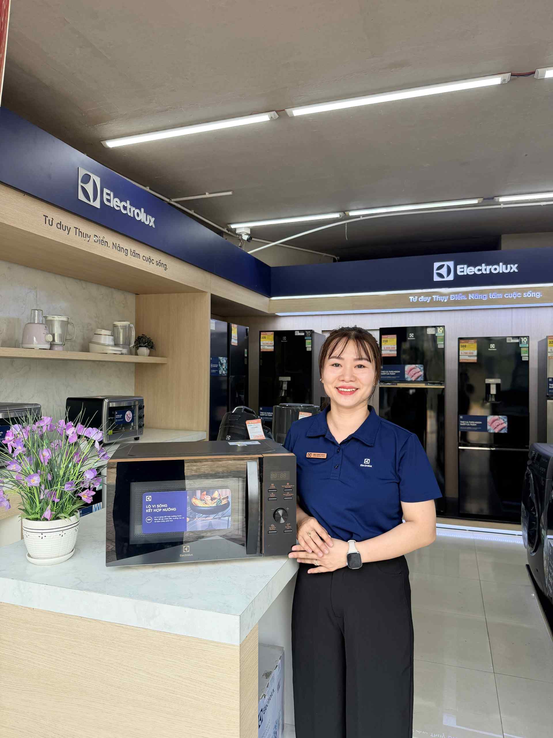 Lò vi sóng Electrolux kết hợp nướng màu đen đặt trên quầy trưng bày tại cửa hàng điện máy